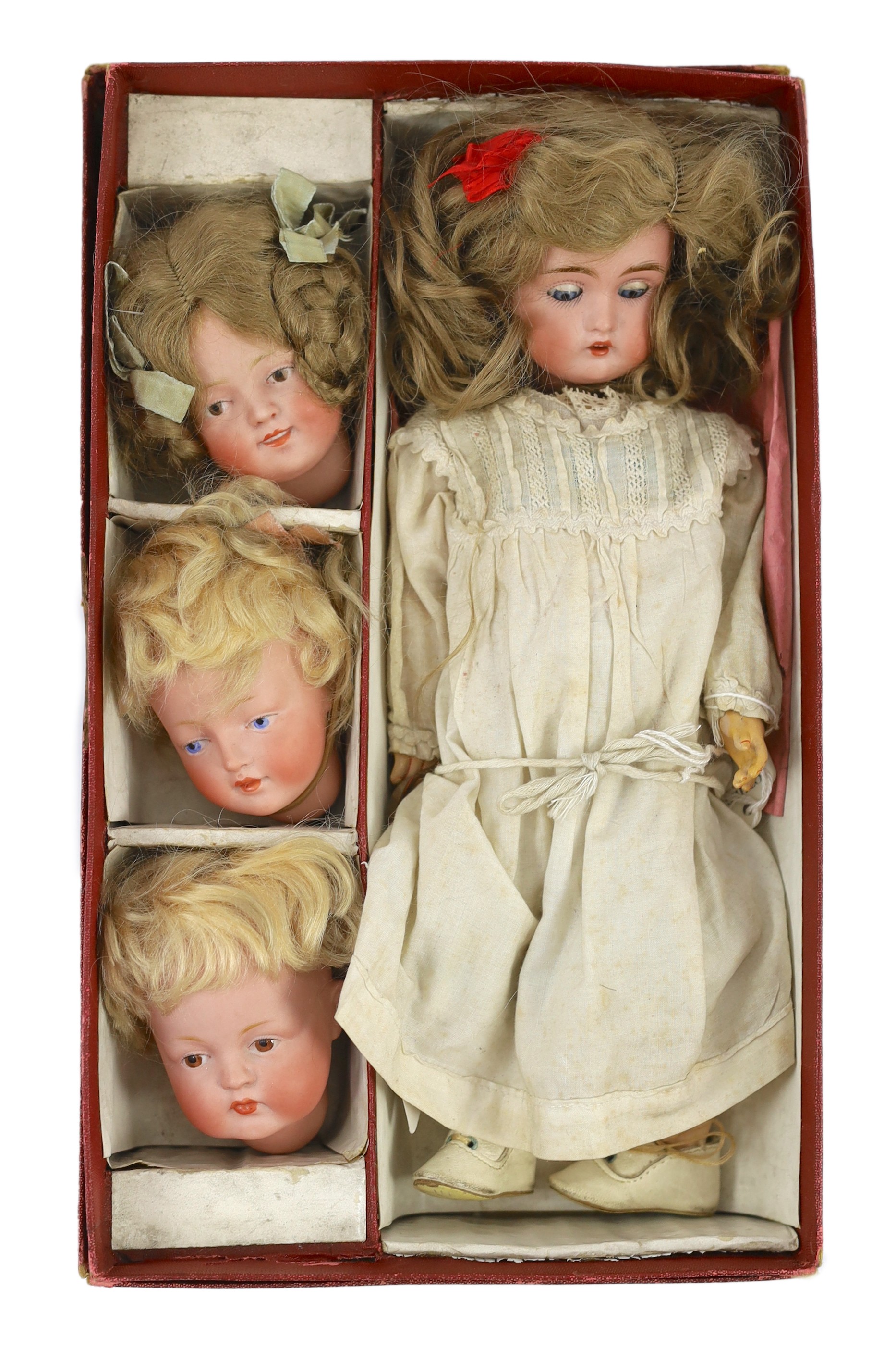 A rare J. D. Kestner bisque character doll, with three interchangeable character heads, German, circa 1910, overall 28cm high, retaining original instructions of how to change heads and the original box